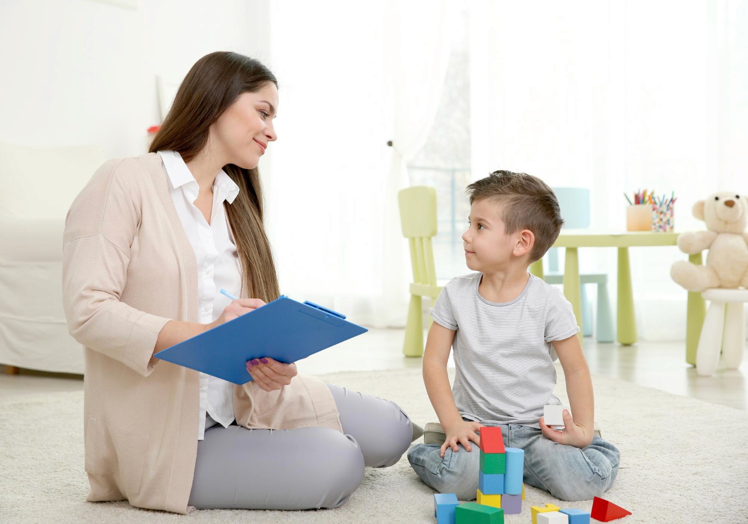 BCBA supporting a young child during a therapy session.