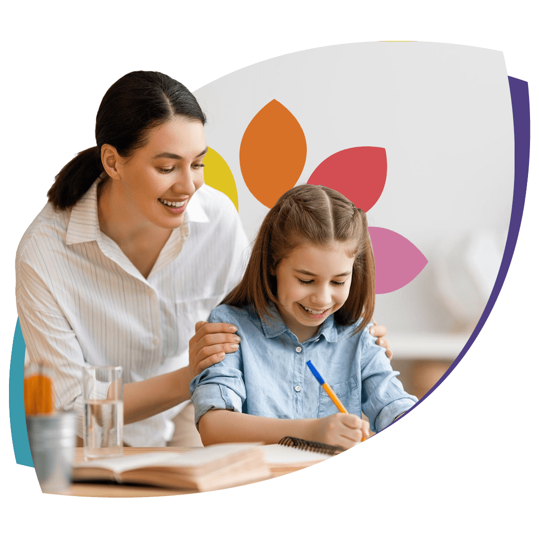 Therapist smiling with a young girl at a table, surrounded by colorful flower petals.